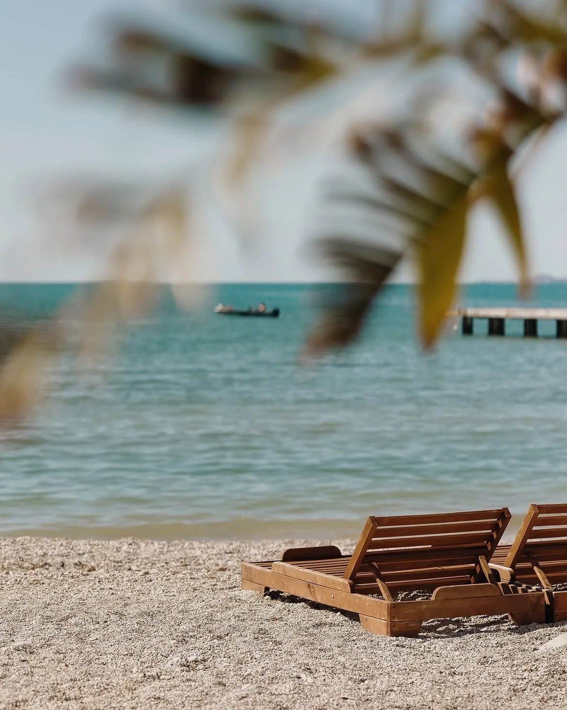 Wooden sun loungers on the beach by the sea at BOJO Resort