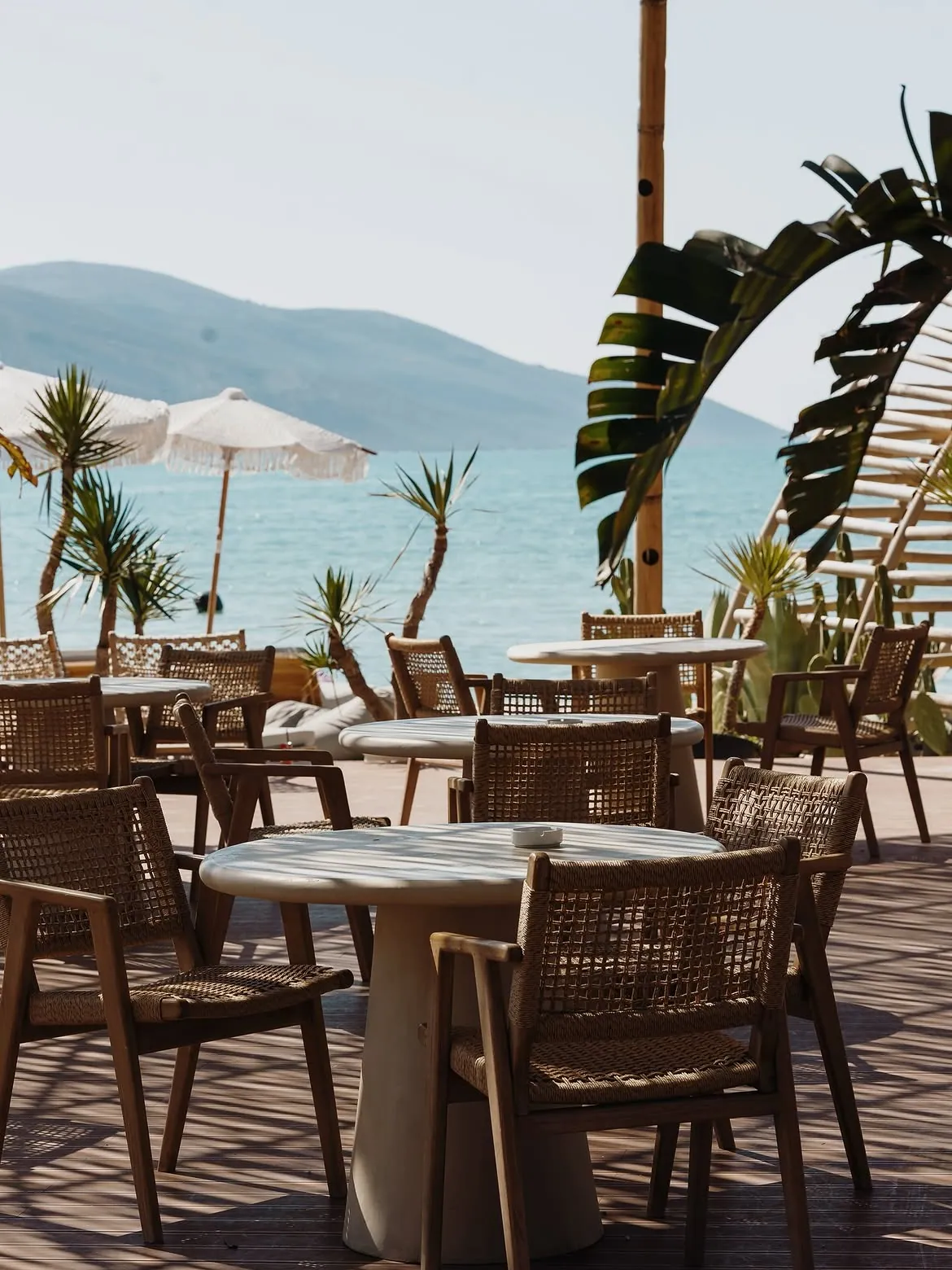 Seafront lounge terrace with umbrellas and sea views at BOJO Resort beach club