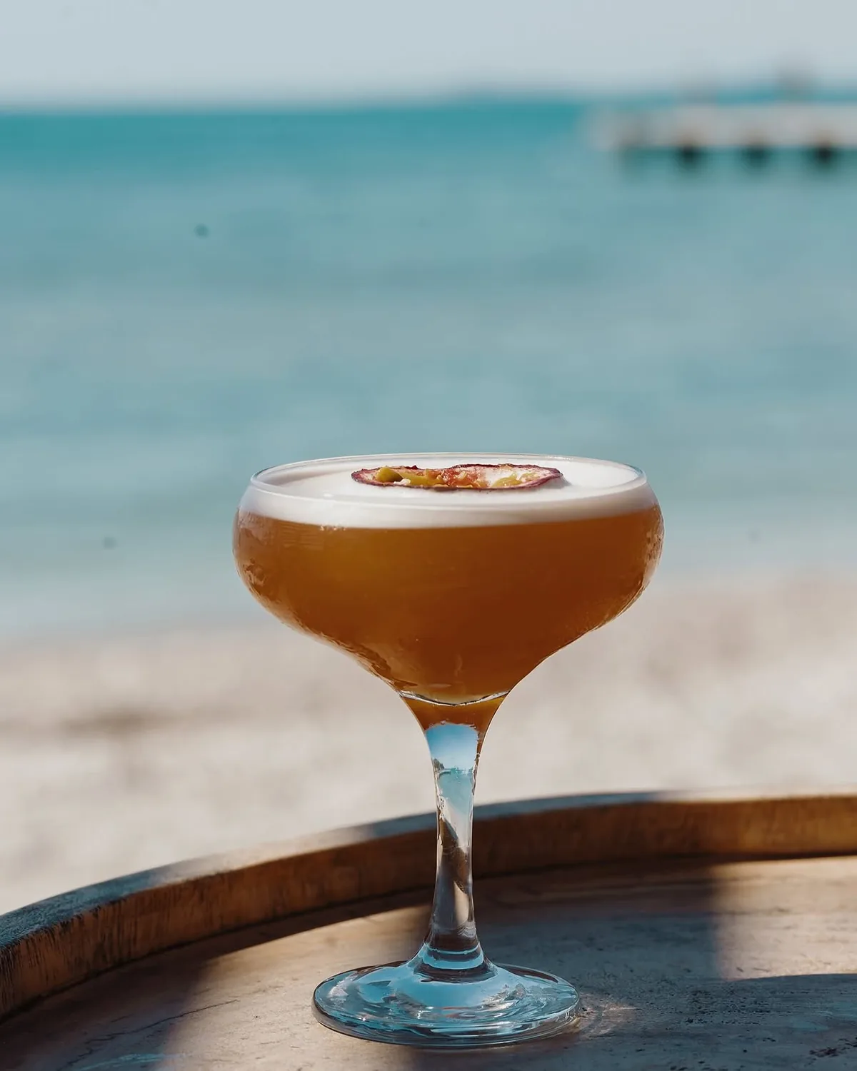 A signature cocktail served by the sea at BOJO Resort