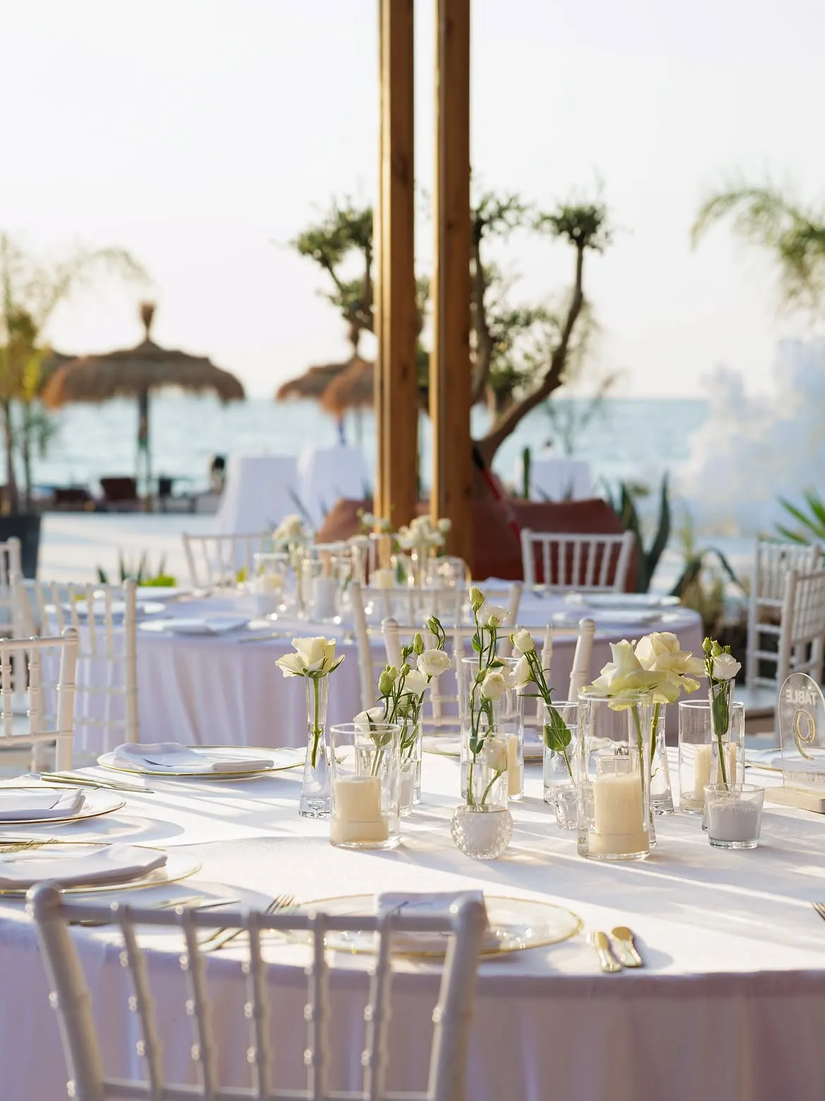 Seaside wedding reception tables set by the water at BOJO Resort