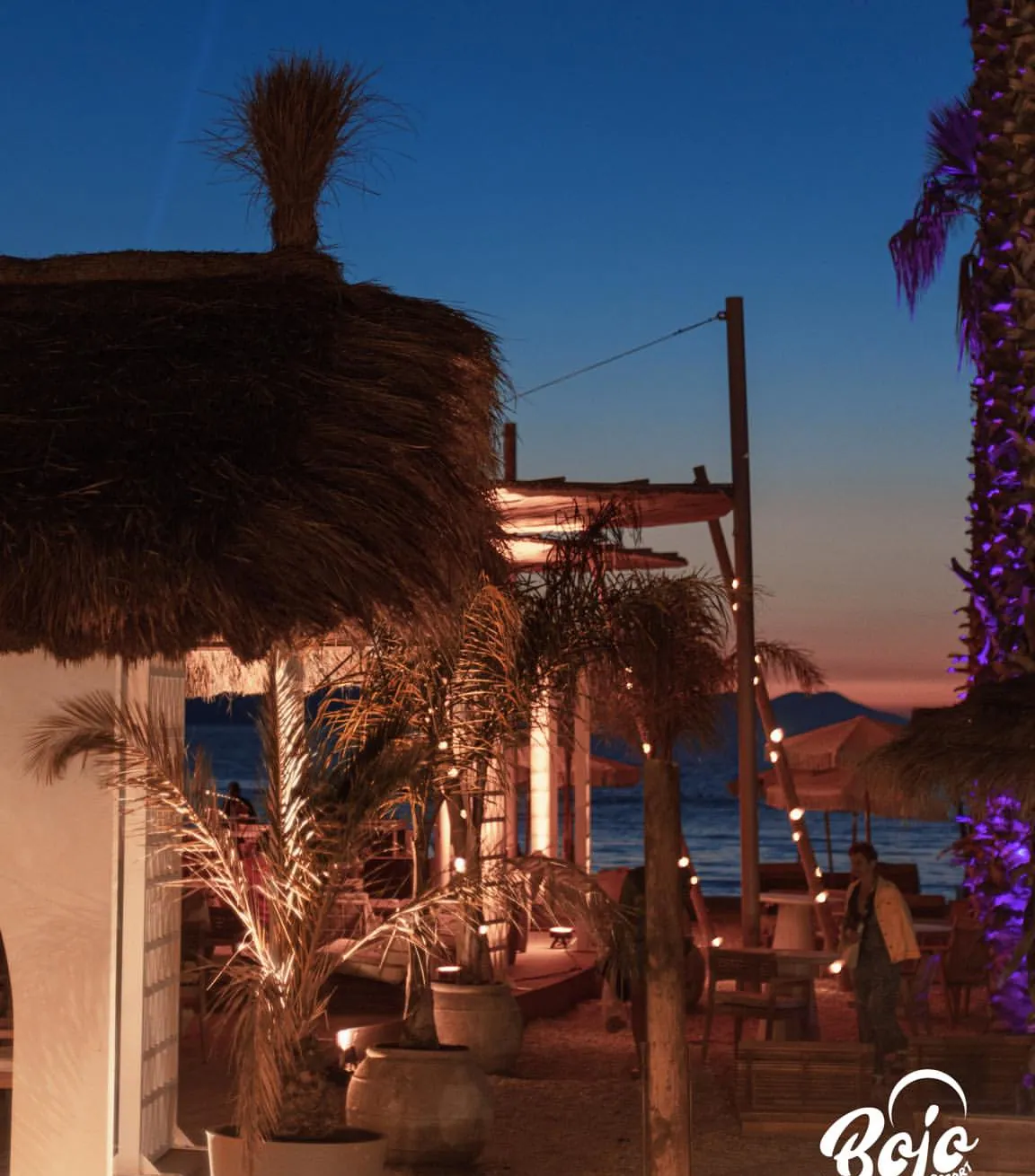 Terrace at golden hour with string lights at BOJO Resort